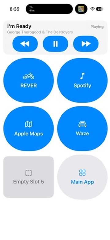 Ride Connected riding control panel showing a playing track, music controls, quick-launch tiles for REVER, Spotify, Apple Maps, and Waze, and a Main App button